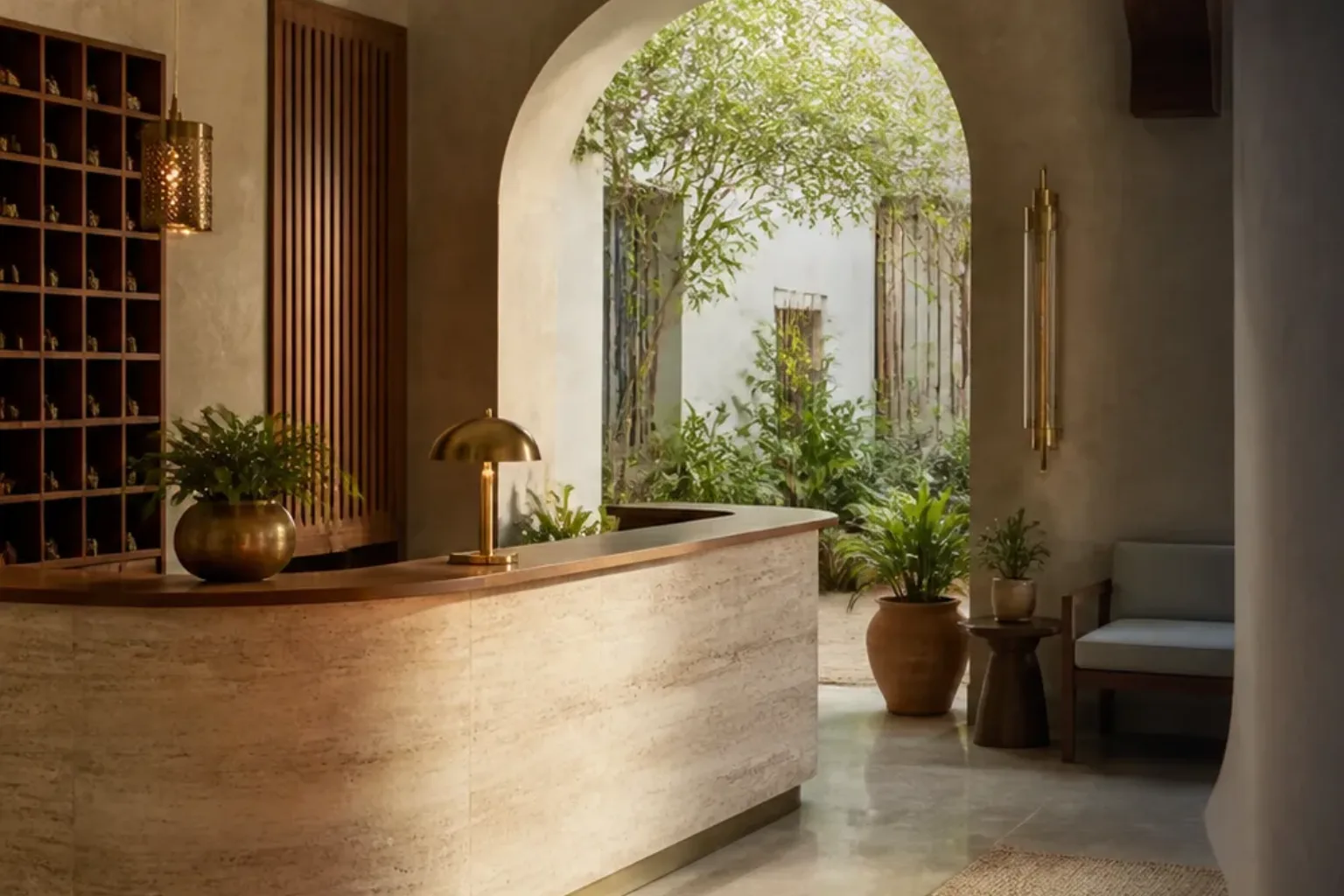 Calm boutique hotel reception desk beside an arched courtyard garden
